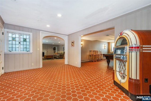 hall featuring baseboards, ornamental molding, and arched walkways