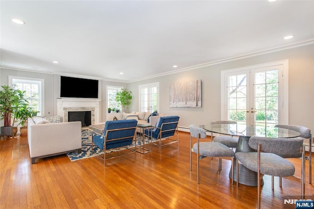 living room featuring french doors, ornamental molding, wood finished floors, and a wealth of natural light