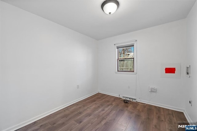 empty room with baseboards and dark wood-style flooring