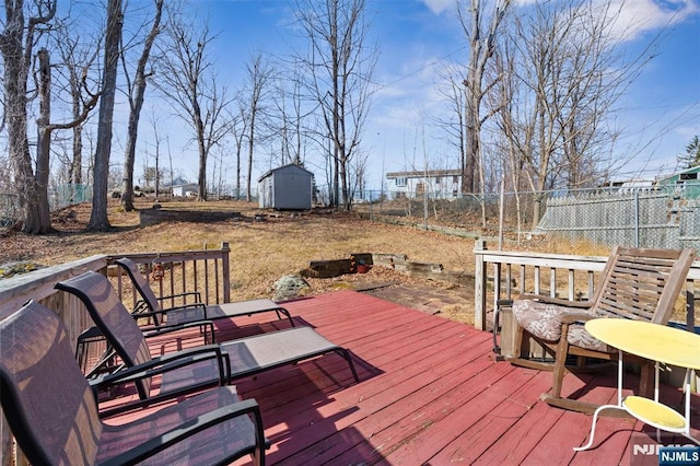 deck featuring a storage unit, an outdoor structure, and fence