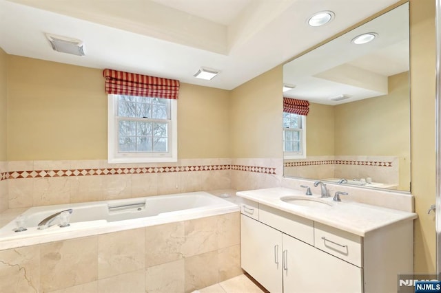 bathroom with visible vents, a garden tub, and vanity
