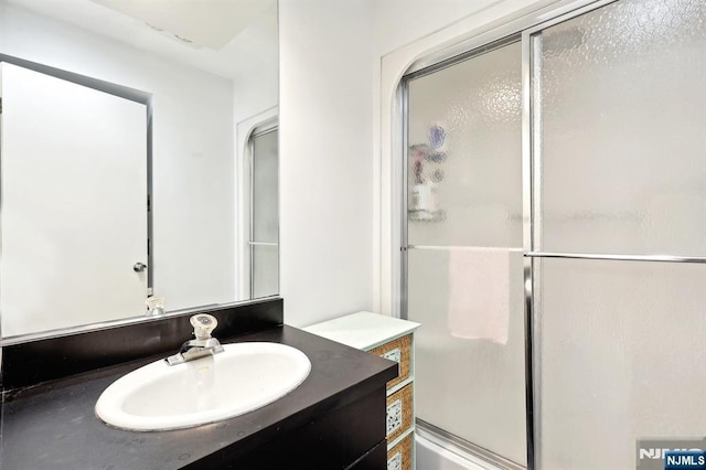 bathroom with a shower stall and vanity