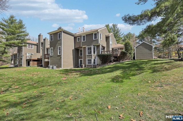 rear view of house with a lawn and a deck