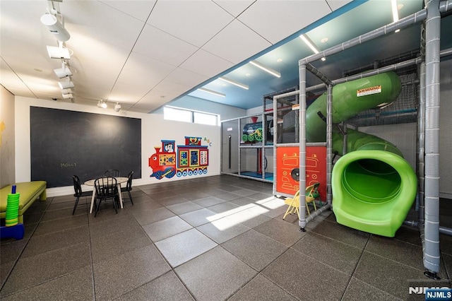 playroom with rail lighting and baseboards