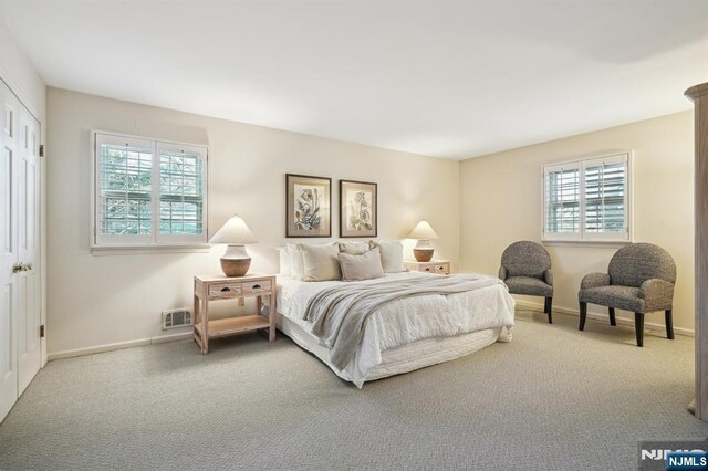 carpeted bedroom featuring baseboards and visible vents