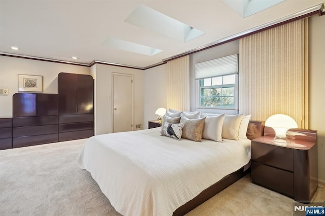 carpeted bedroom featuring ornamental molding, a skylight, and recessed lighting
