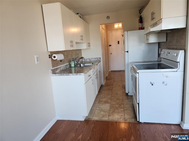 kitchen featuring white cabinets, tasteful backsplash, a sink, light wood-style floors, and electric range