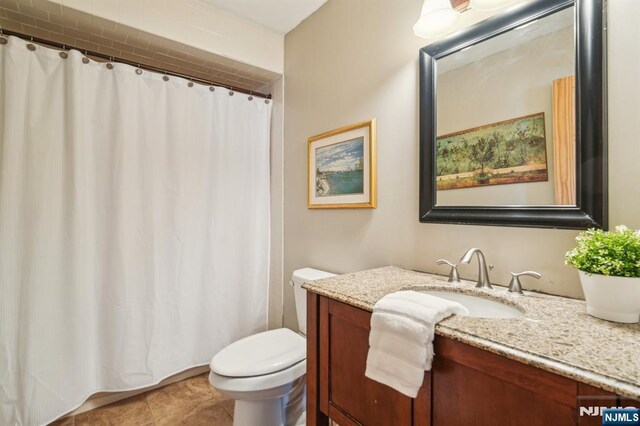 full bath with toilet, vanity, curtained shower, and tile patterned flooring