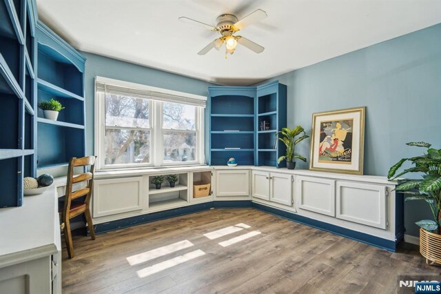 living area with dark wood-type flooring and ceiling fan