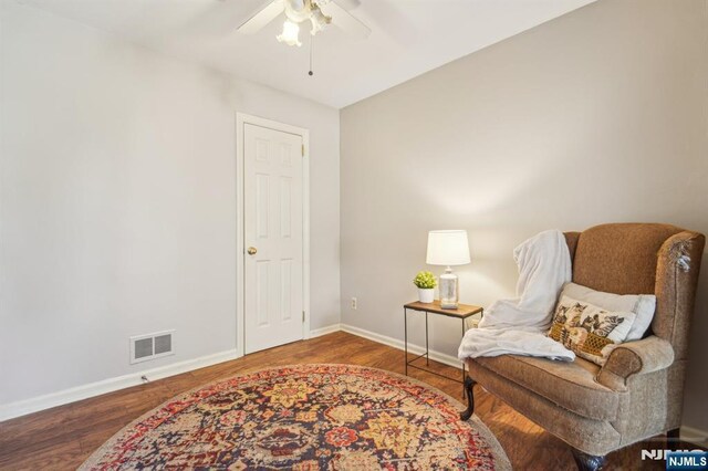 sitting room featuring wood finished floors, baseboards, ceiling fan, and visible vents
