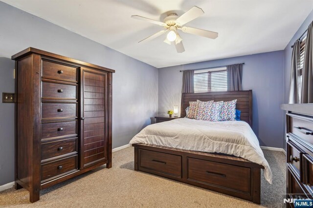 bedroom featuring baseboards, ceiling fan, and light carpet