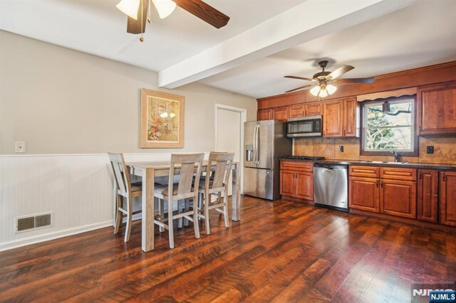 kitchen with ceiling fan, visible vents, stainless steel appliances, and dark countertops