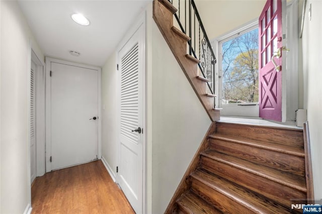stairway with baseboards, recessed lighting, and wood finished floors