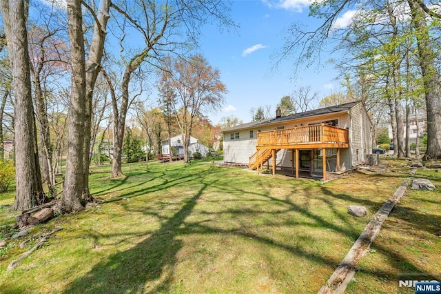 back of house with a yard, a deck, a chimney, and stairs