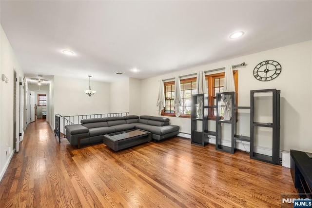 living area with plenty of natural light, a baseboard radiator, wood finished floors, and recessed lighting