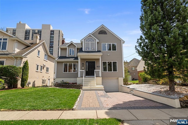 view of front facade with decorative driveway, an attached garage, and a front lawn