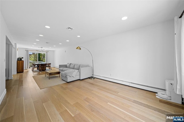living room featuring visible vents, a baseboard radiator, light wood-style floors, and recessed lighting