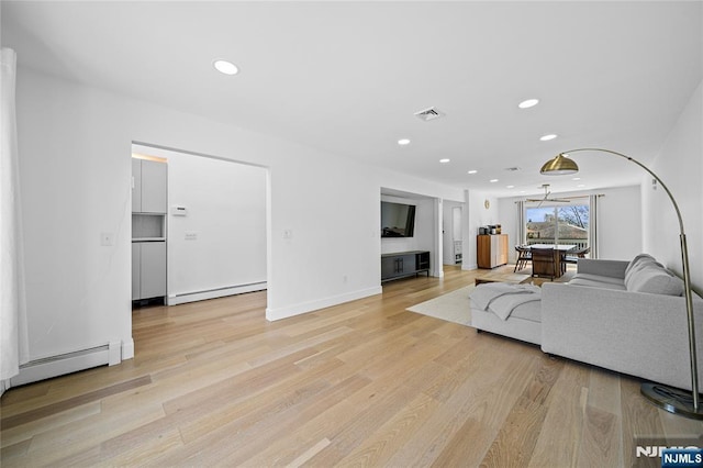 living room with light wood-type flooring, a baseboard heating unit, recessed lighting, and visible vents