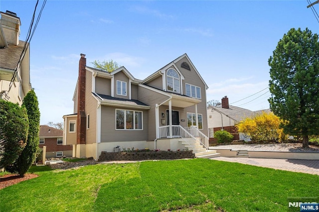 traditional-style house featuring a chimney and a front yard