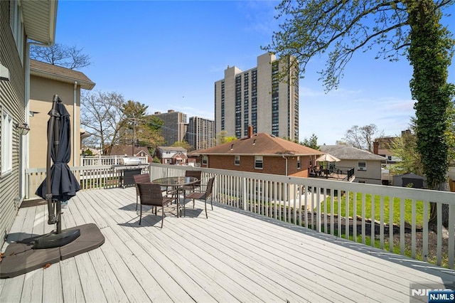 deck featuring outdoor dining area and a residential view