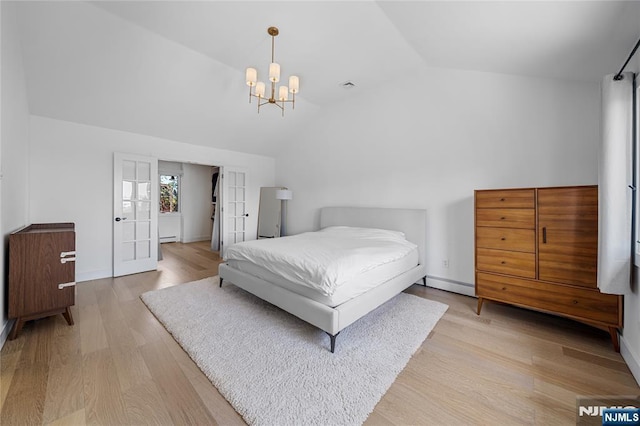 bedroom featuring baseboards, a notable chandelier, lofted ceiling, and light wood-type flooring