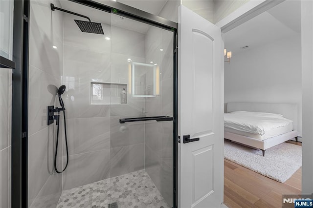bathroom featuring a stall shower, ensuite bath, and wood finished floors