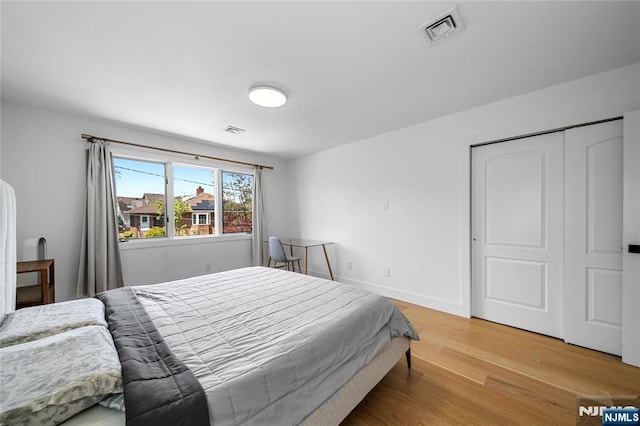 bedroom with visible vents, baseboards, a closet, and light wood-type flooring