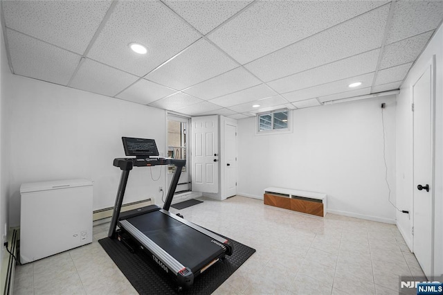exercise area featuring recessed lighting, baseboards, a drop ceiling, and baseboard heating