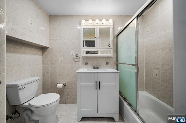 full bathroom with tile patterned flooring, vanity, toilet, enclosed tub / shower combo, and tile walls