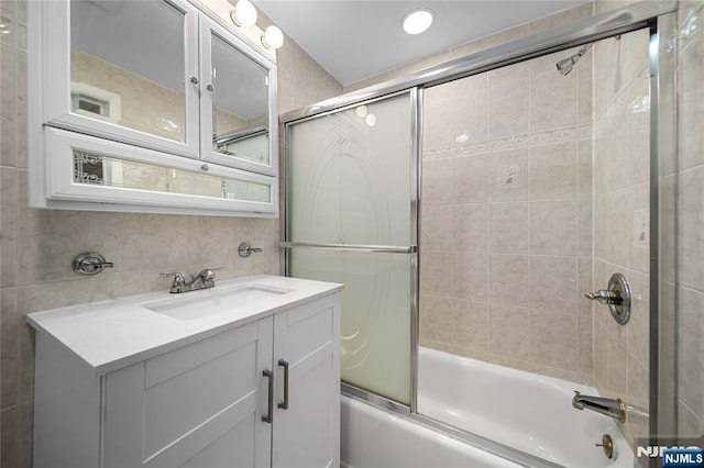 full bathroom with vanity and bath / shower combo with glass door