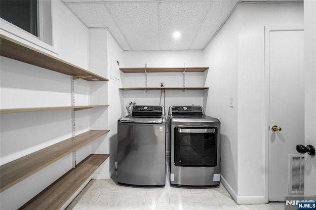 washroom with washing machine and clothes dryer, laundry area, baseboards, light tile patterned floors, and visible vents