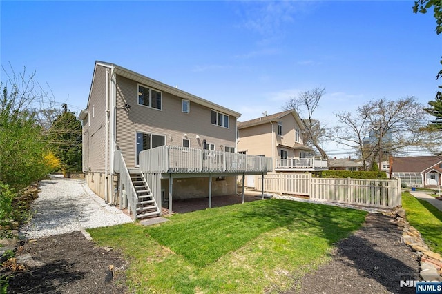 rear view of property featuring fence, a wooden deck, a yard, and stairway