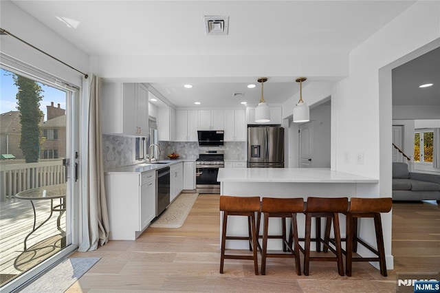 kitchen featuring light countertops, appliances with stainless steel finishes, plenty of natural light, and visible vents