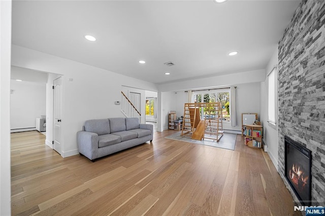 living area with visible vents, a fireplace, stairway, light wood-style floors, and recessed lighting