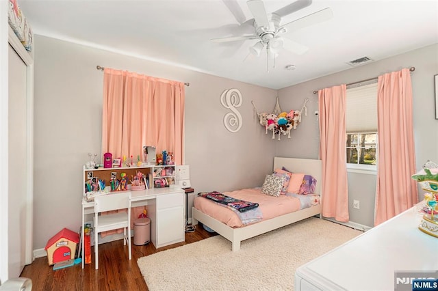 bedroom featuring dark wood finished floors, visible vents, and a ceiling fan
