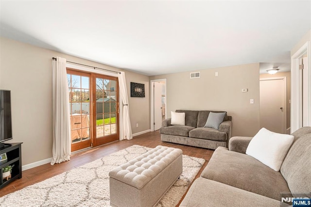 living room with baseboards, wood finished floors, and visible vents