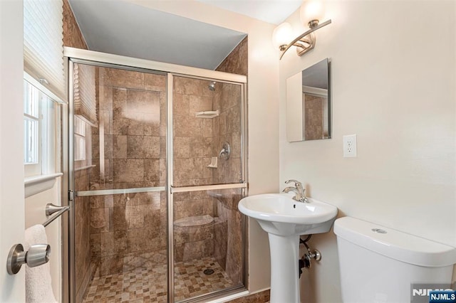 bathroom with toilet and a stall shower