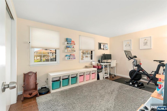 workout area featuring baseboards and wood finished floors
