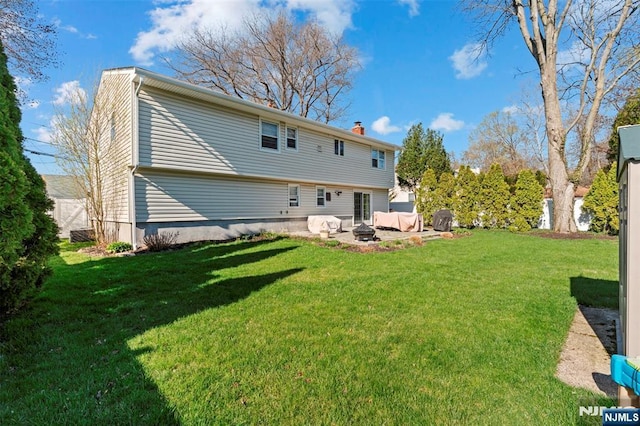 back of property featuring a fire pit, a chimney, and a yard