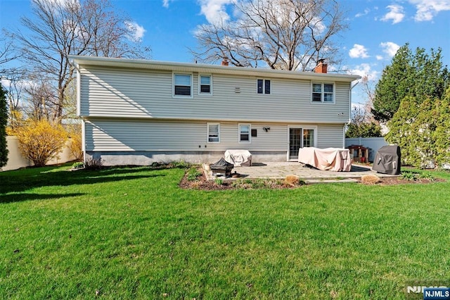 back of house with fence, a patio area, a chimney, and a yard