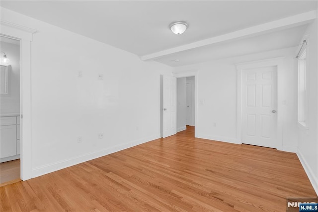 interior space with baseboards and light wood finished floors