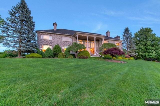 16 Shinnecock Trl, Franklin Lakes, NJ 07417 - view of front of house with a chimney and a front yard