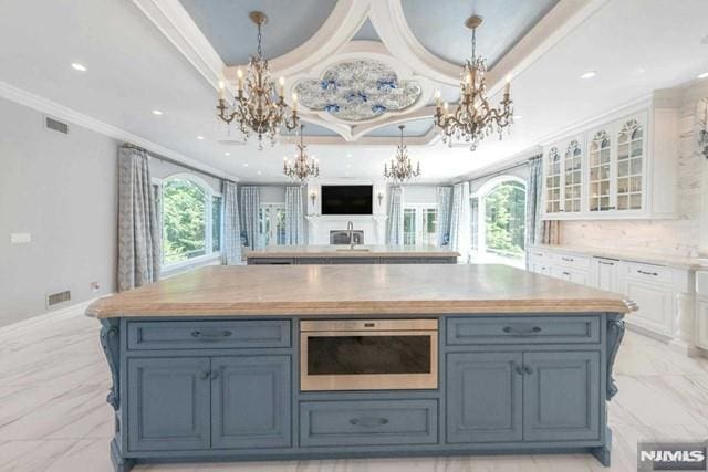 16 Shinnecock Trl, Franklin Lakes, NJ 07417 - kitchen with marble finish floor, white cabinets, an inviting chandelier, and crown molding
