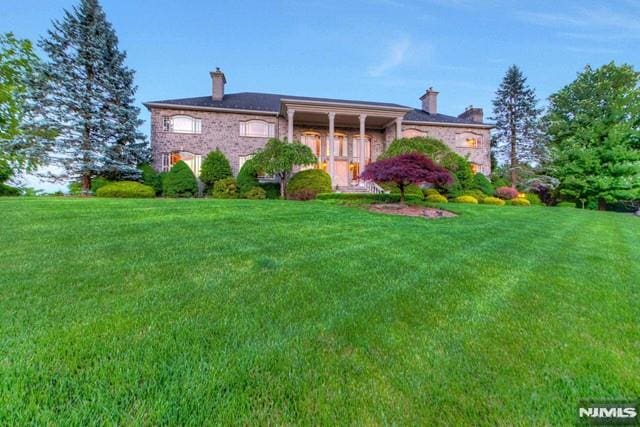16 Shinnecock Trl, Franklin Lakes, NJ 07417 - view of front of home with a chimney and a front yard