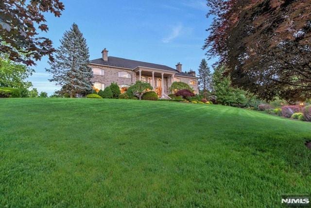 16 Shinnecock Trl, Franklin Lakes, NJ 07417 - view of front of house with a front yard and a chimney