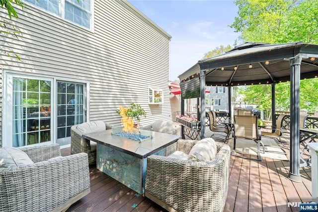 deck featuring a gazebo and outdoor dining space