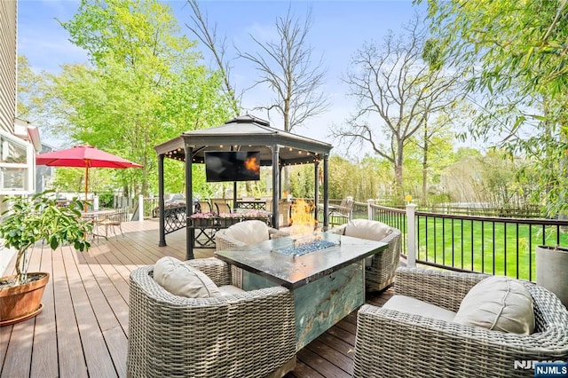 deck featuring a gazebo, fence, a yard, a fire pit, and outdoor dining space