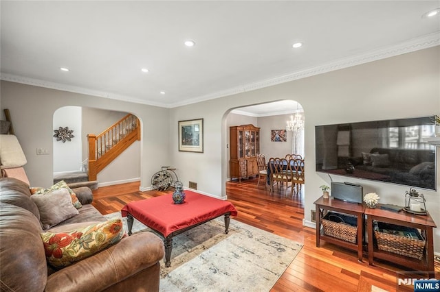 living room with stairs, arched walkways, a chandelier, and recessed lighting