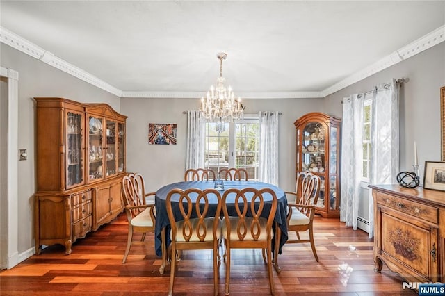 dining area with an inviting chandelier, ornamental molding, wood finished floors, and a wealth of natural light