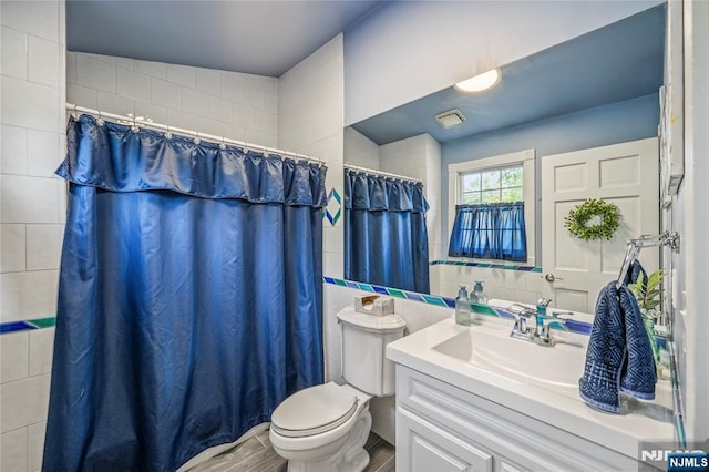 full bathroom featuring toilet, tile walls, curtained shower, and vanity